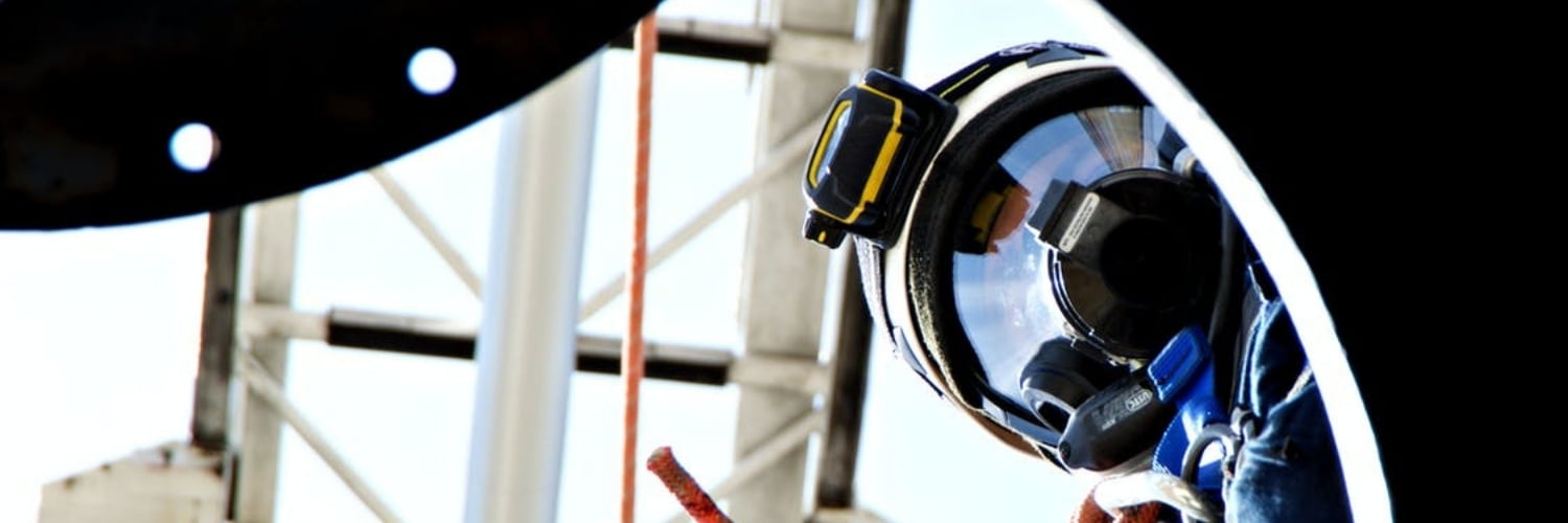 Man looking in whole where a confined space permit is requiredConfined